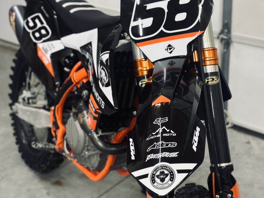 KTM dirt bike with a Cache Moto sticker on the number plate