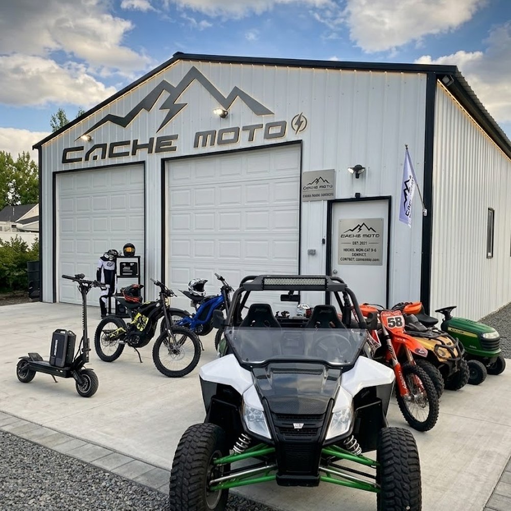 The front of the Cache Moto shop in Nibley, Utah, with the mountain sign above the bay doors