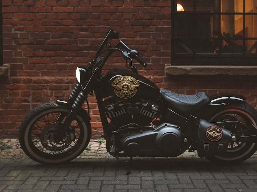 Blacked-out cruiser motorcycle parked on a brick street